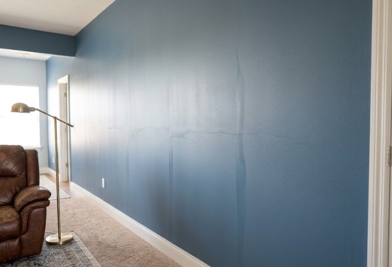 Blue wall with vertical and horizontal bands where rolled sections overlapped